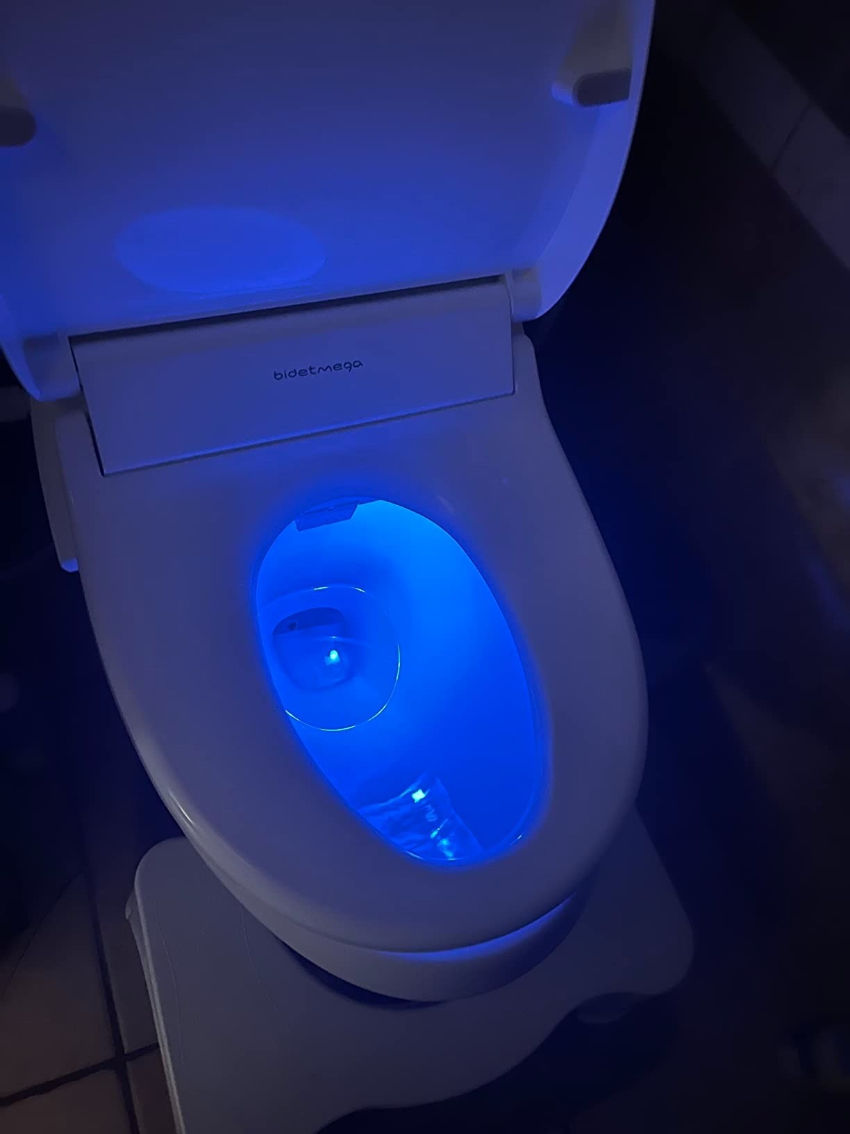 a reviewer photo of the toilet glowing blue