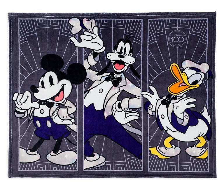 A navy blue fleece with 3 panels featuring mickey, goofy, and donald, in dressed up long tailed tuxedos