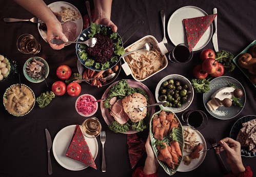 People pass around dishes at Christmas dinner