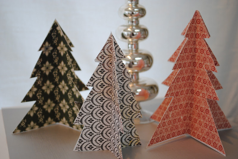 three mini trees made of scrapbook paper in different styles
