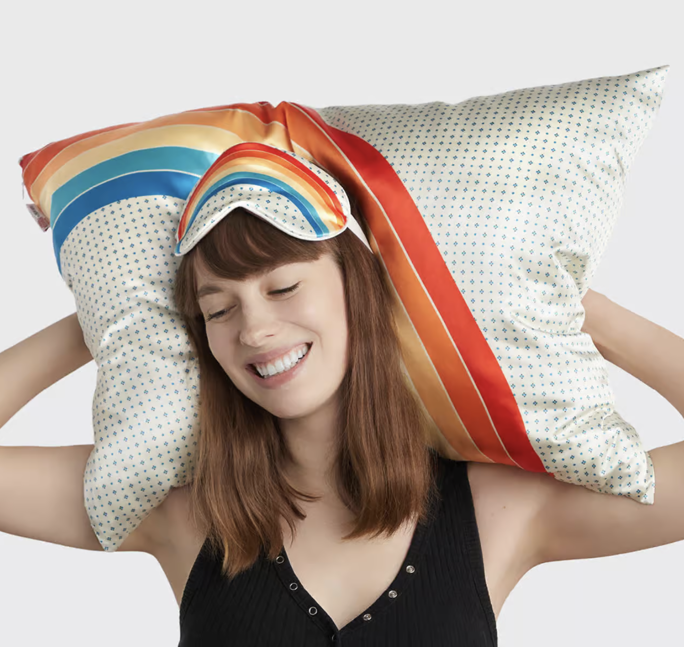 a person holding up a pillow with the pillowcase while wearing the eye mask