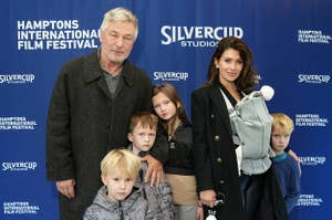 Alec Baldwin and Hilaria Baldwin wear black outfits while standing with five of their seven children.