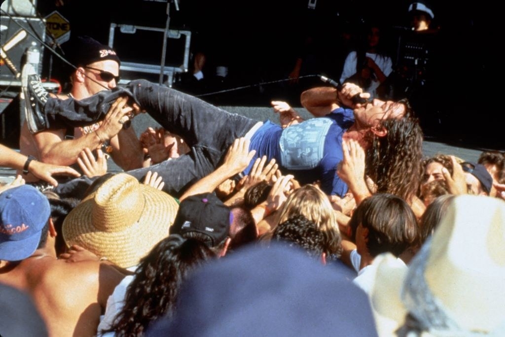 A musician singing while crowdsurfing
