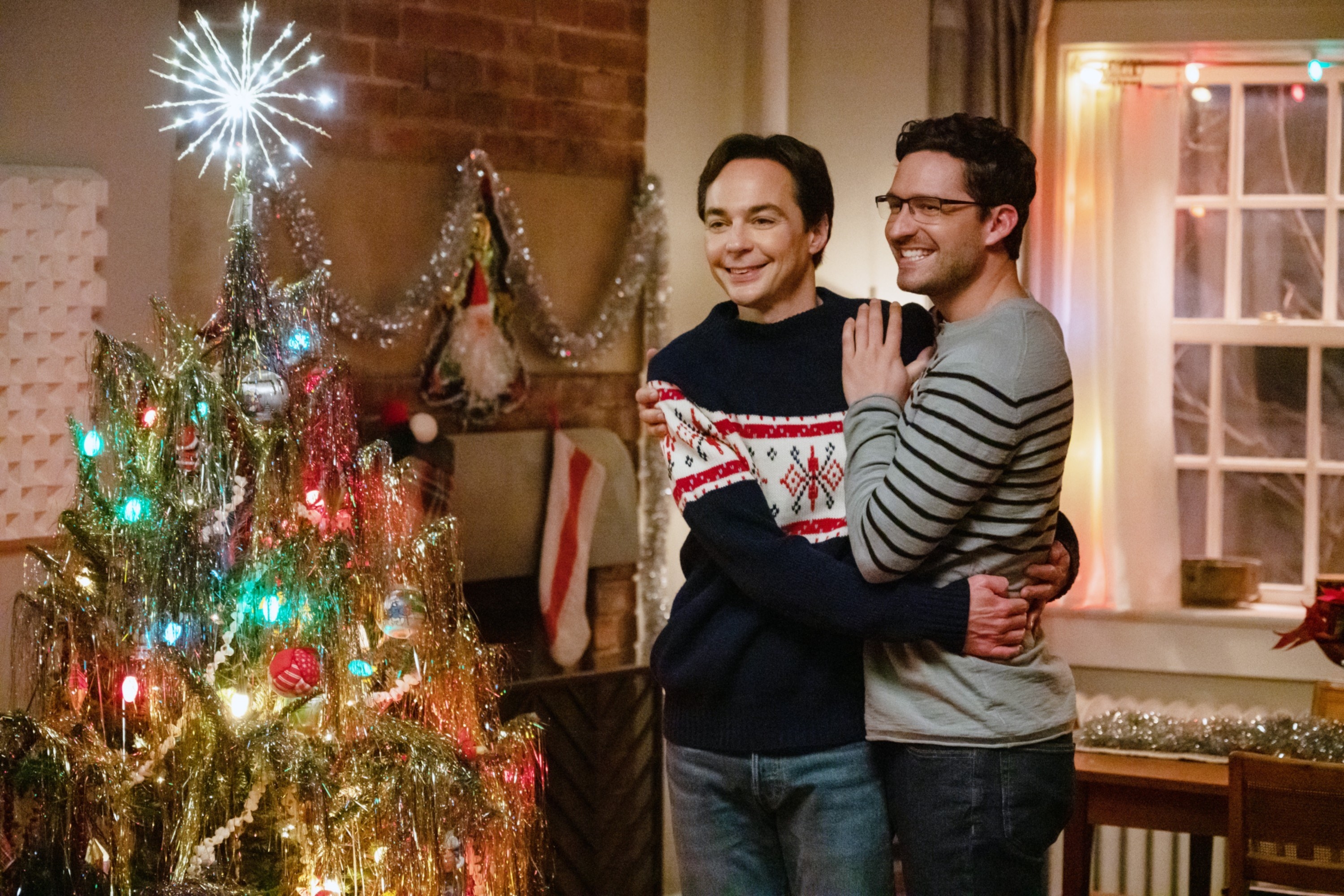 a couple hugging by a Christmas tree