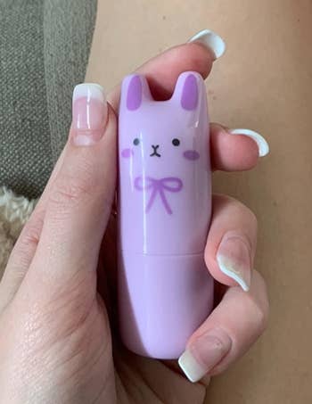 reviewer holding a purple bunny perfume stick