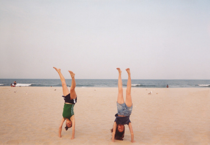 People doing handstands on the beach