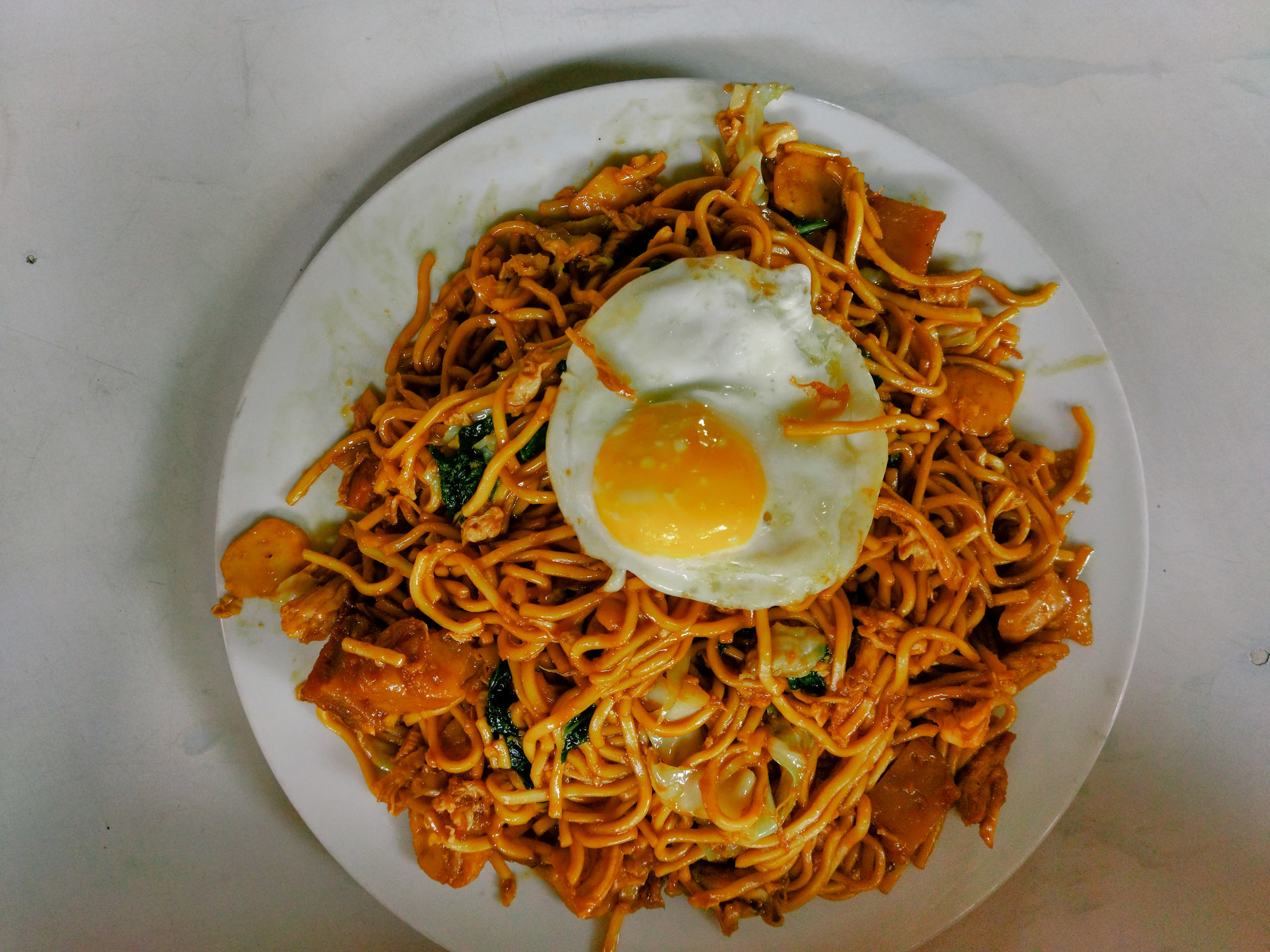 Fried noodles with fried egg on top.