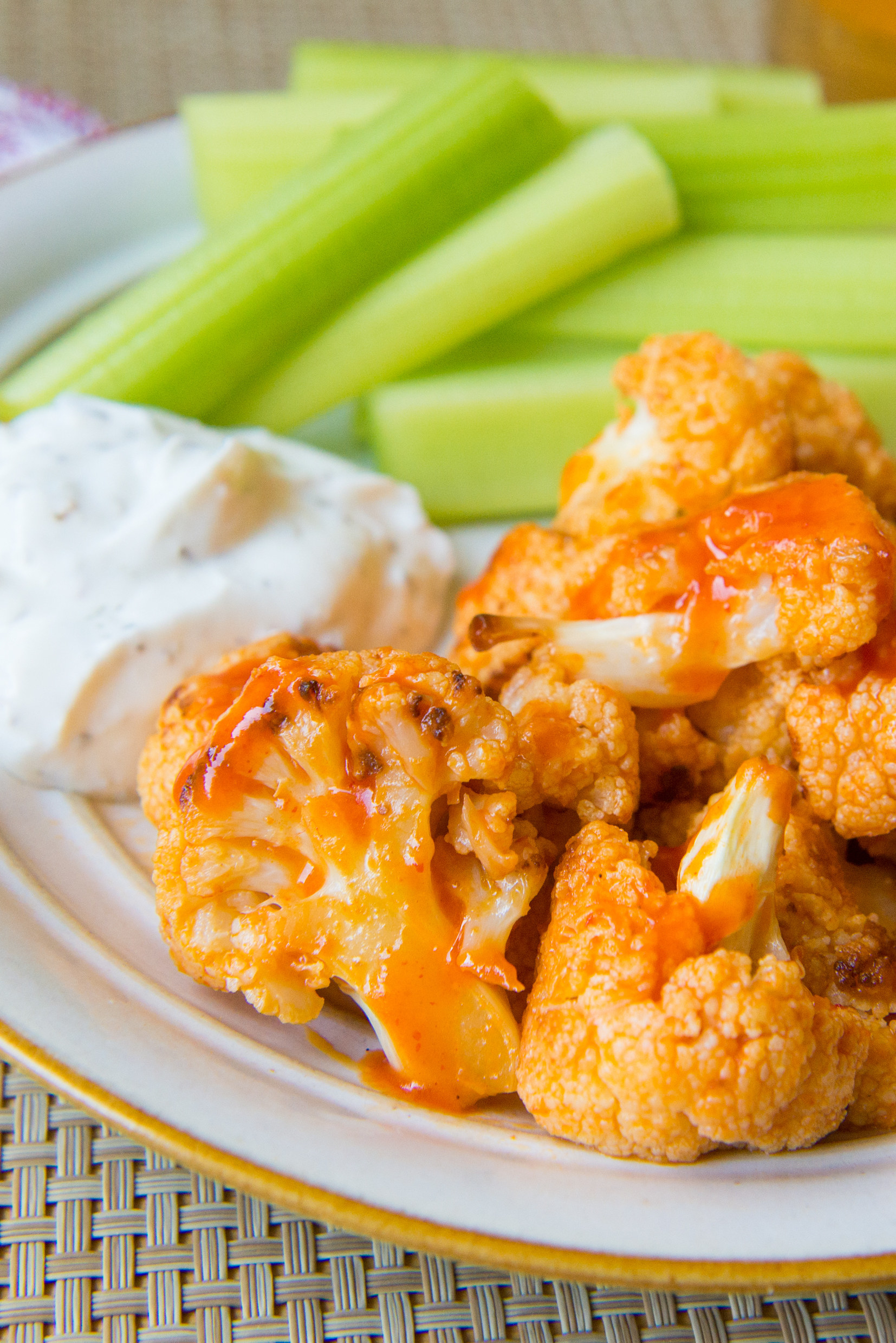 Spicy Buffalo cauliflower bites with dip and celery.