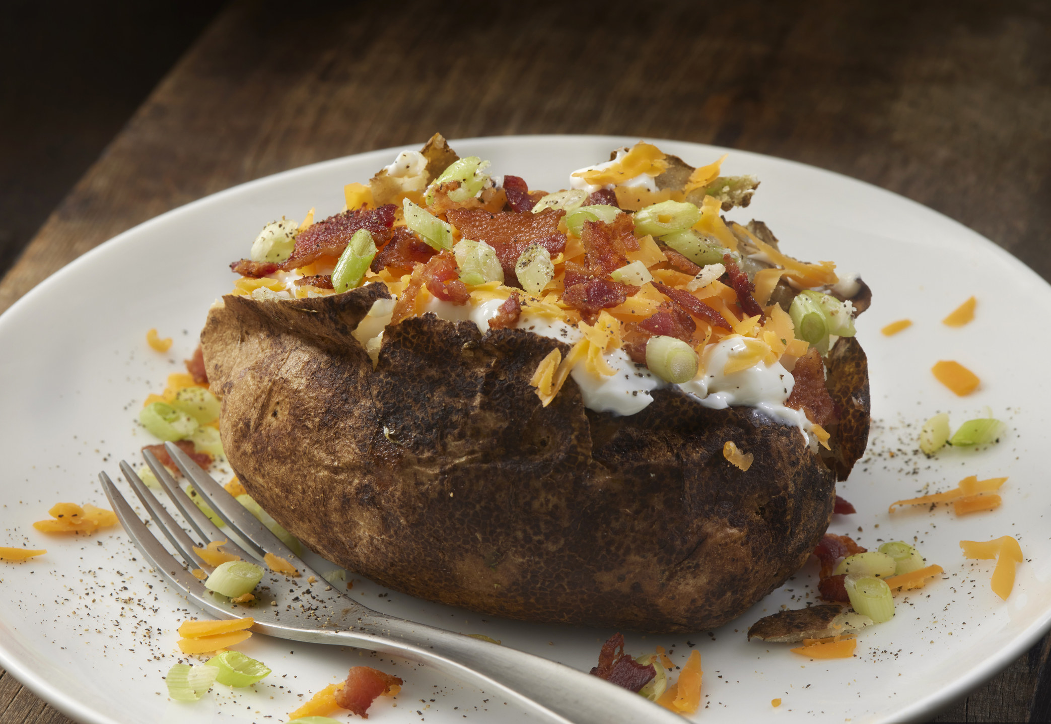 Loaded Baked Potato with Bacon, Sour Cream, Cheddar Cheese and Scallions.
