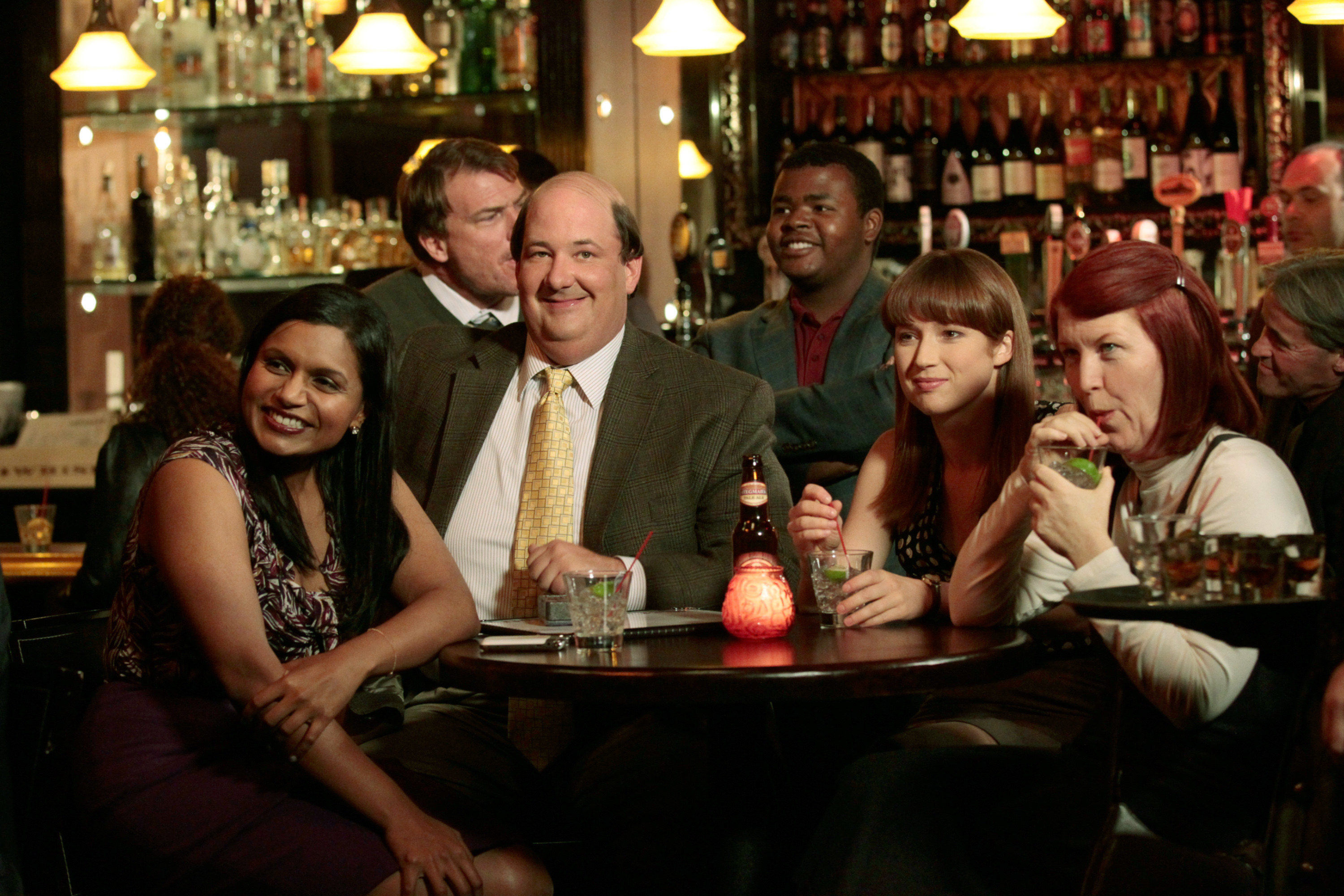 Mindy and some of her Office co-stars sit in a bar