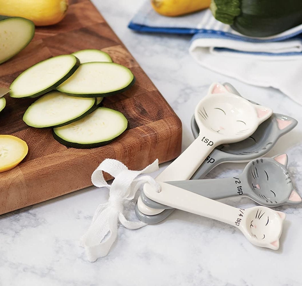 four cat-shaped measuring spoons on a counter