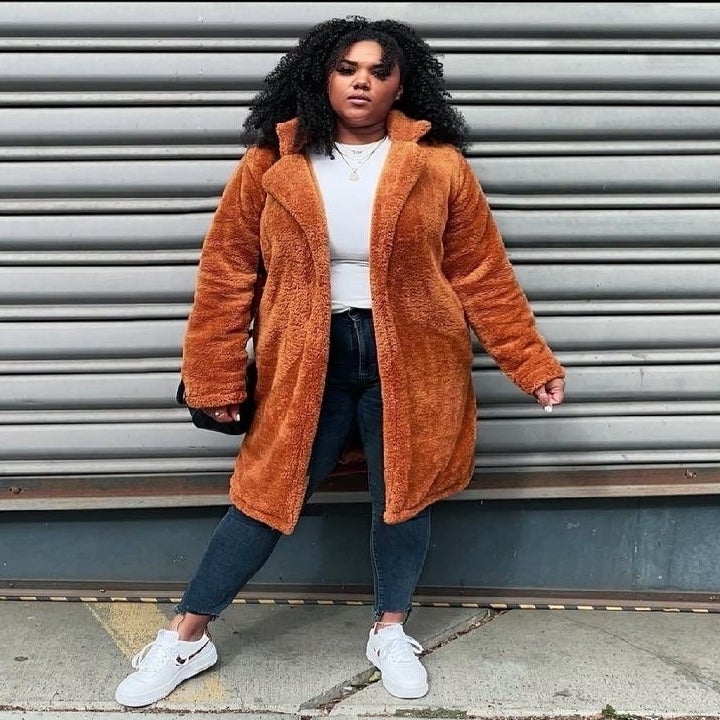 a reviewer wearing the rust colored jacket