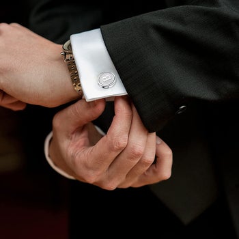 model wearing silver cufflinks with the letter 