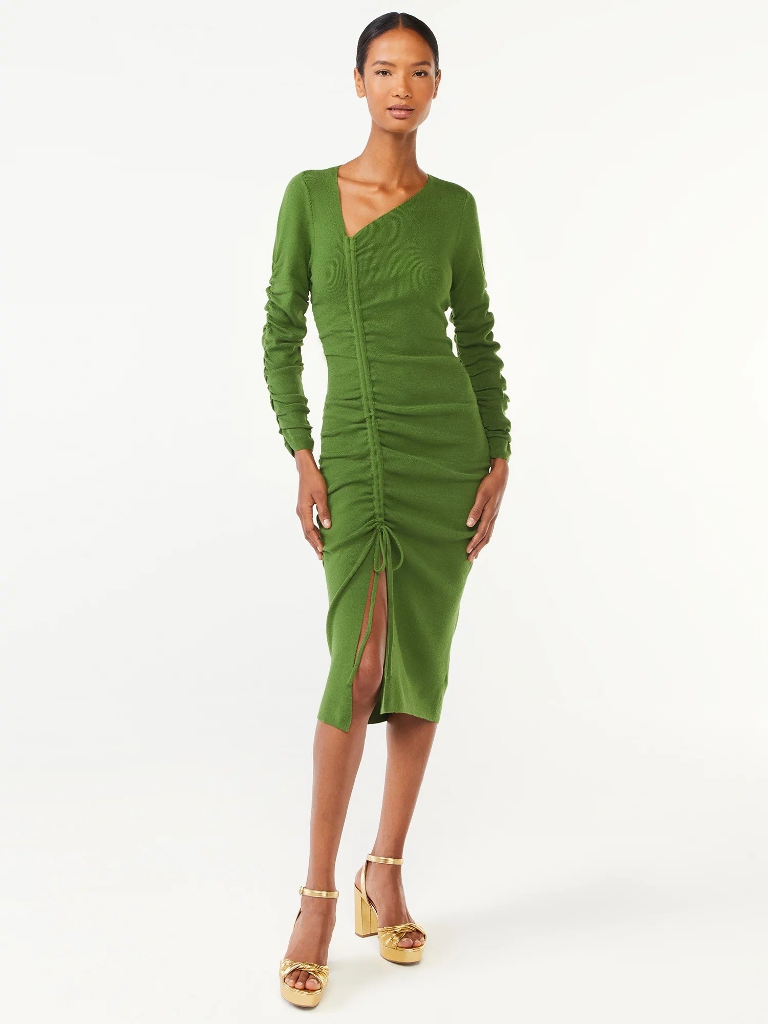 a model wearing the green dress and gold shoes