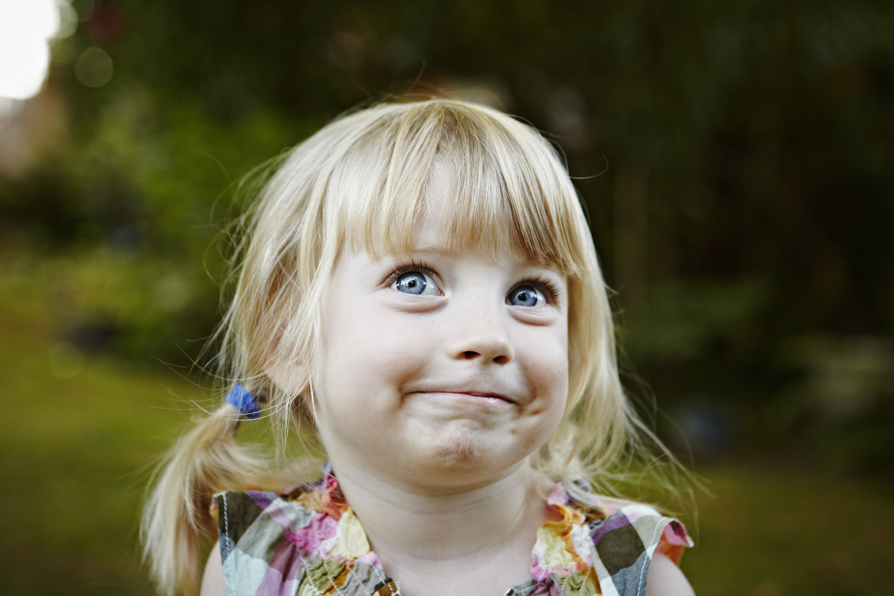 little girl in pigtails with big eyes and a mischievous smile