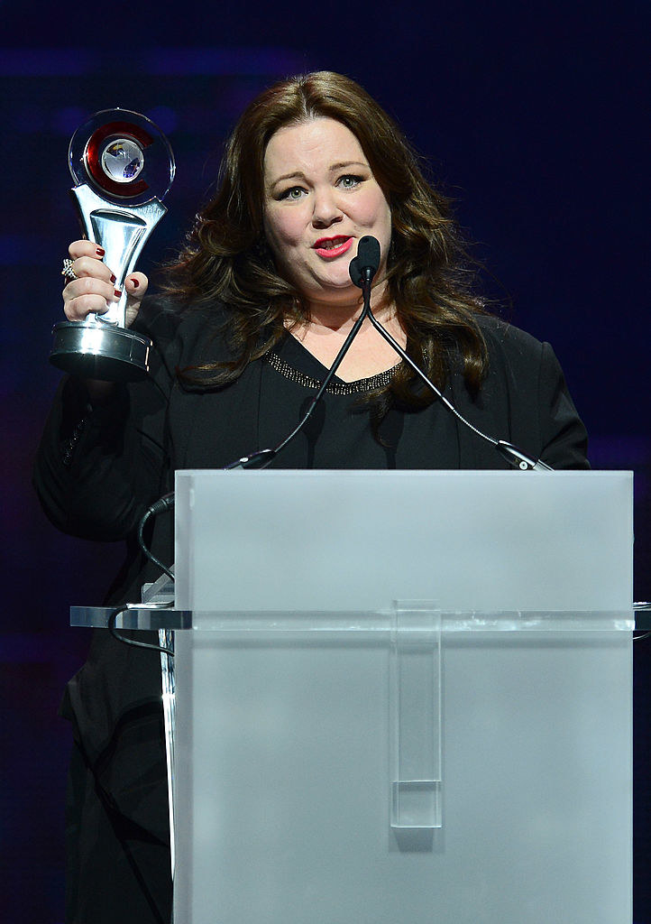 Melissa at a podium holding an award