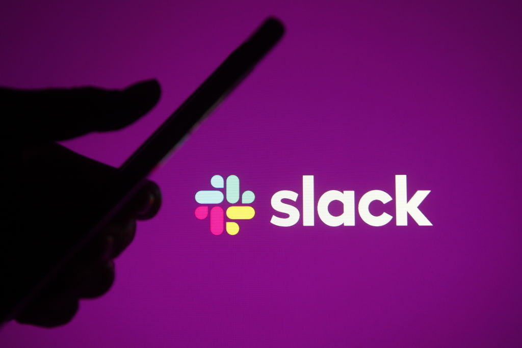 person using a phone in front of the slack logo