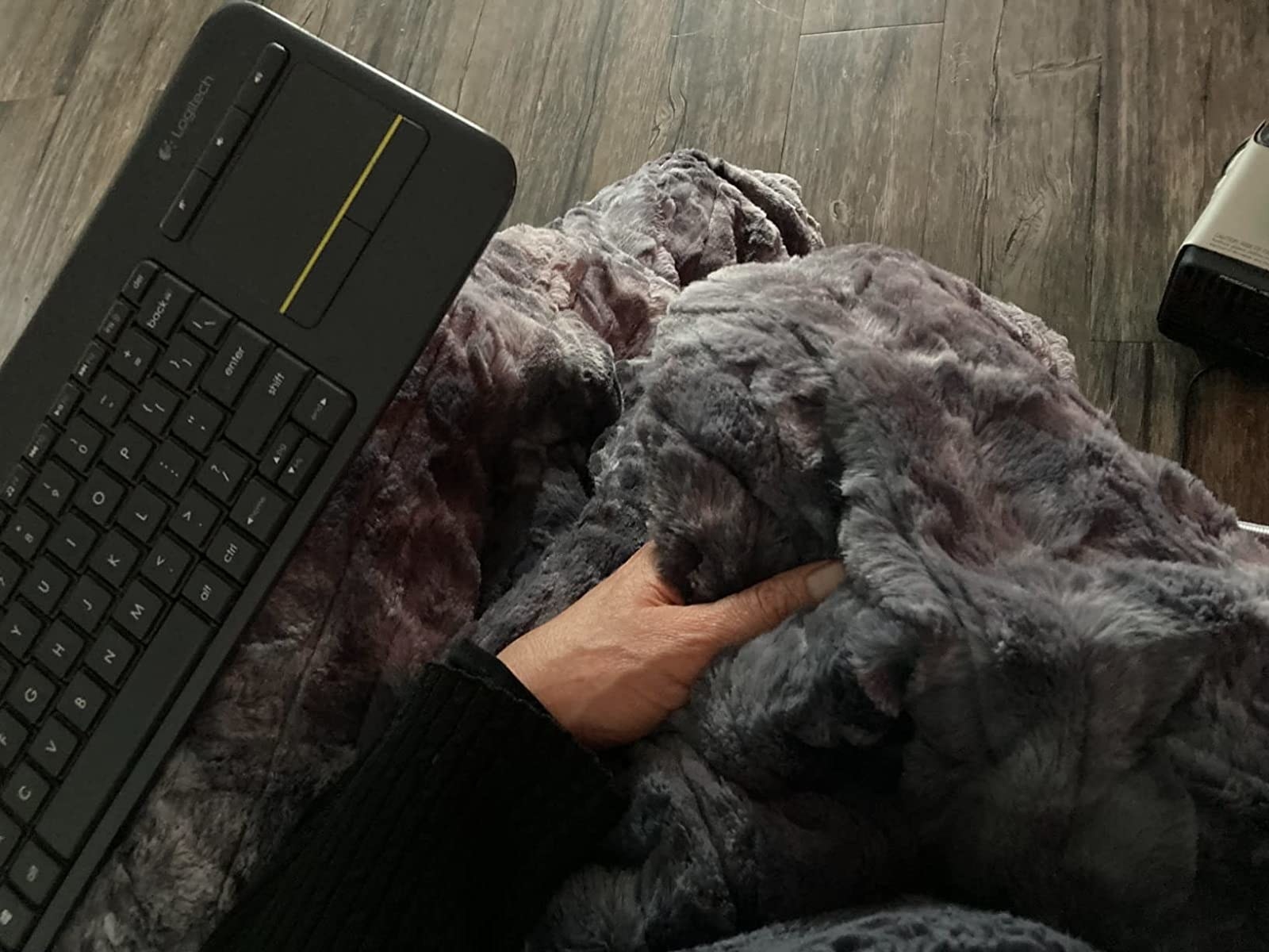 Reviewer holding heated blanket next to keyboard