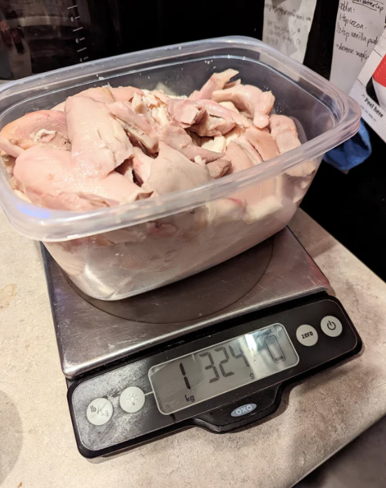 shredded up rotisserie chicken meat that fills up a container on a scale