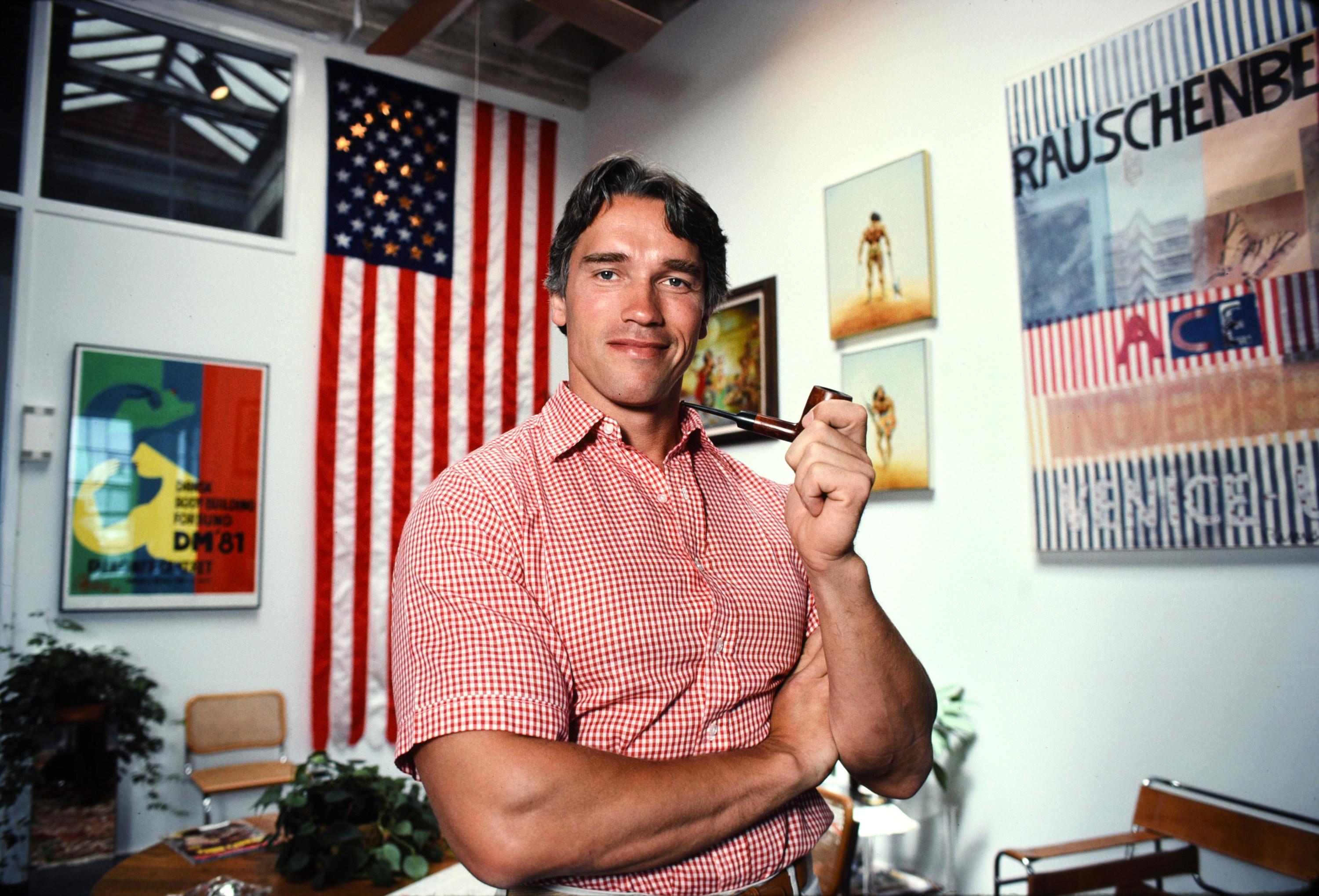 Arnold in a short-sleeved shirt holding a pipe