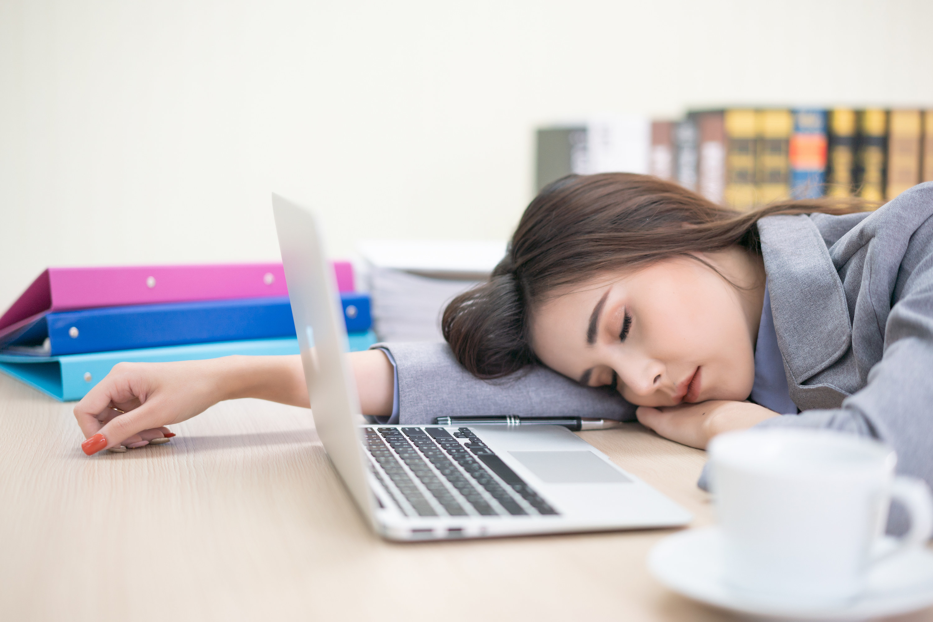 Woman sleeping in front of a laptop