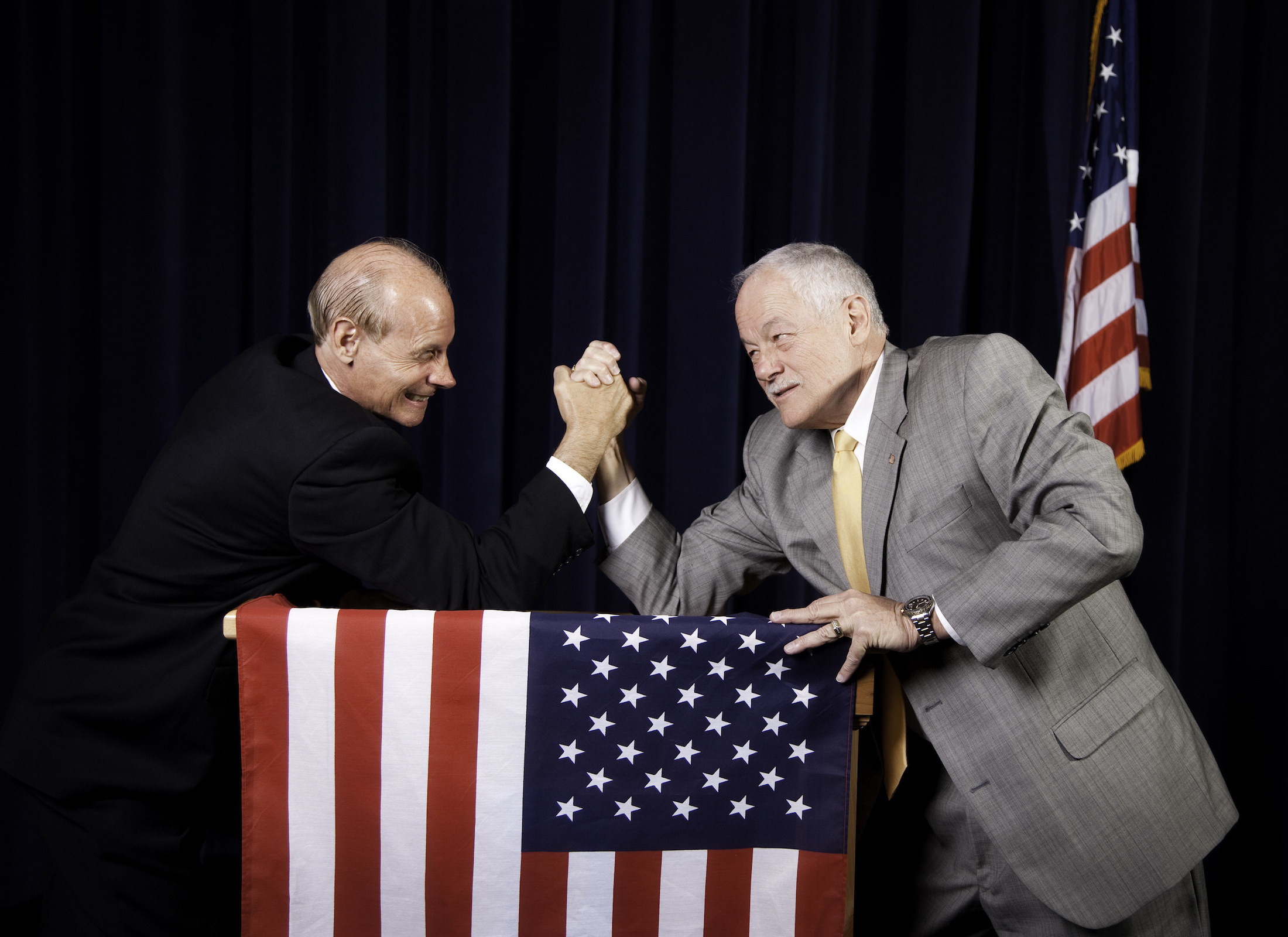 Two men wrestling above a US flag