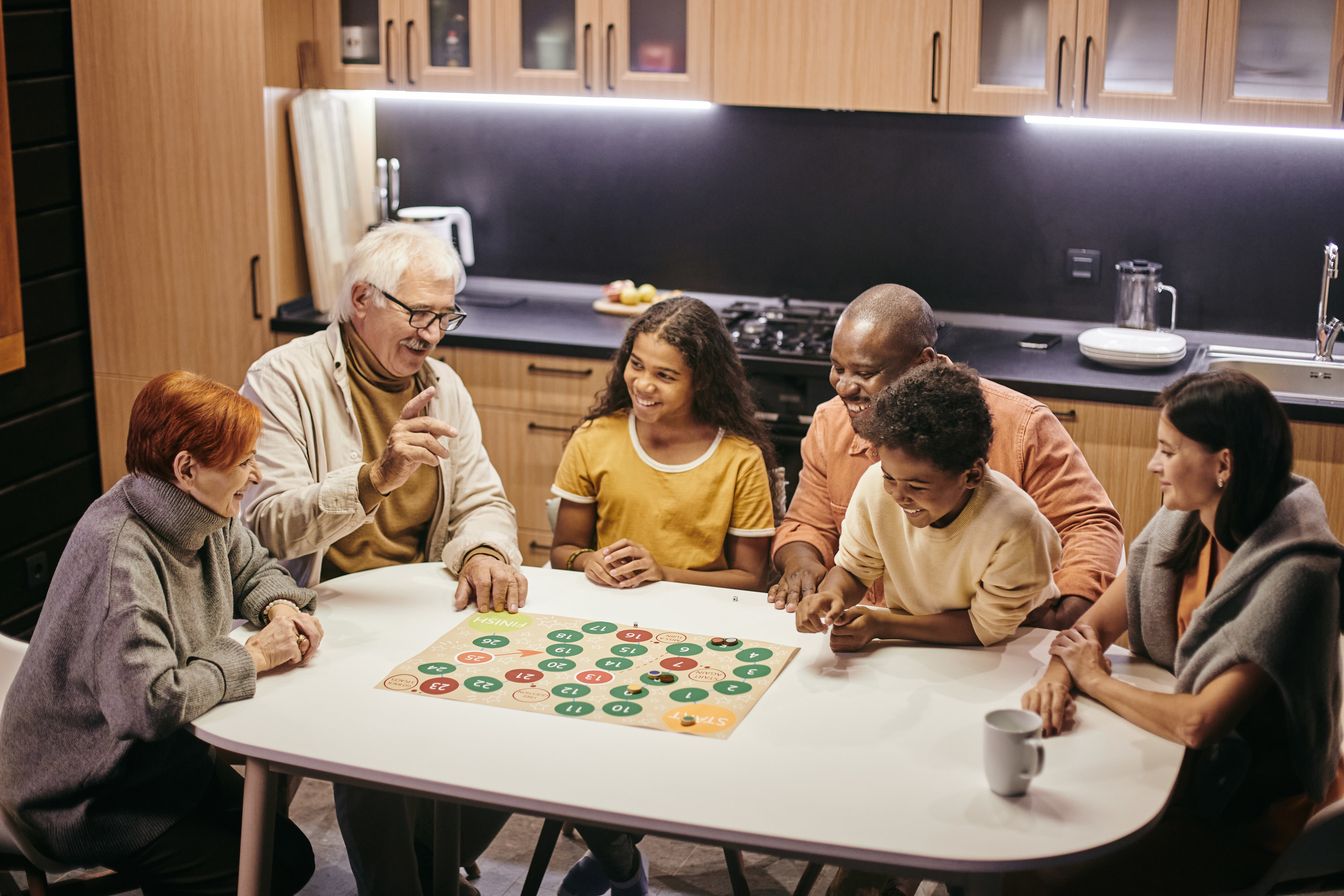 Family sitting around a table playing a board game together