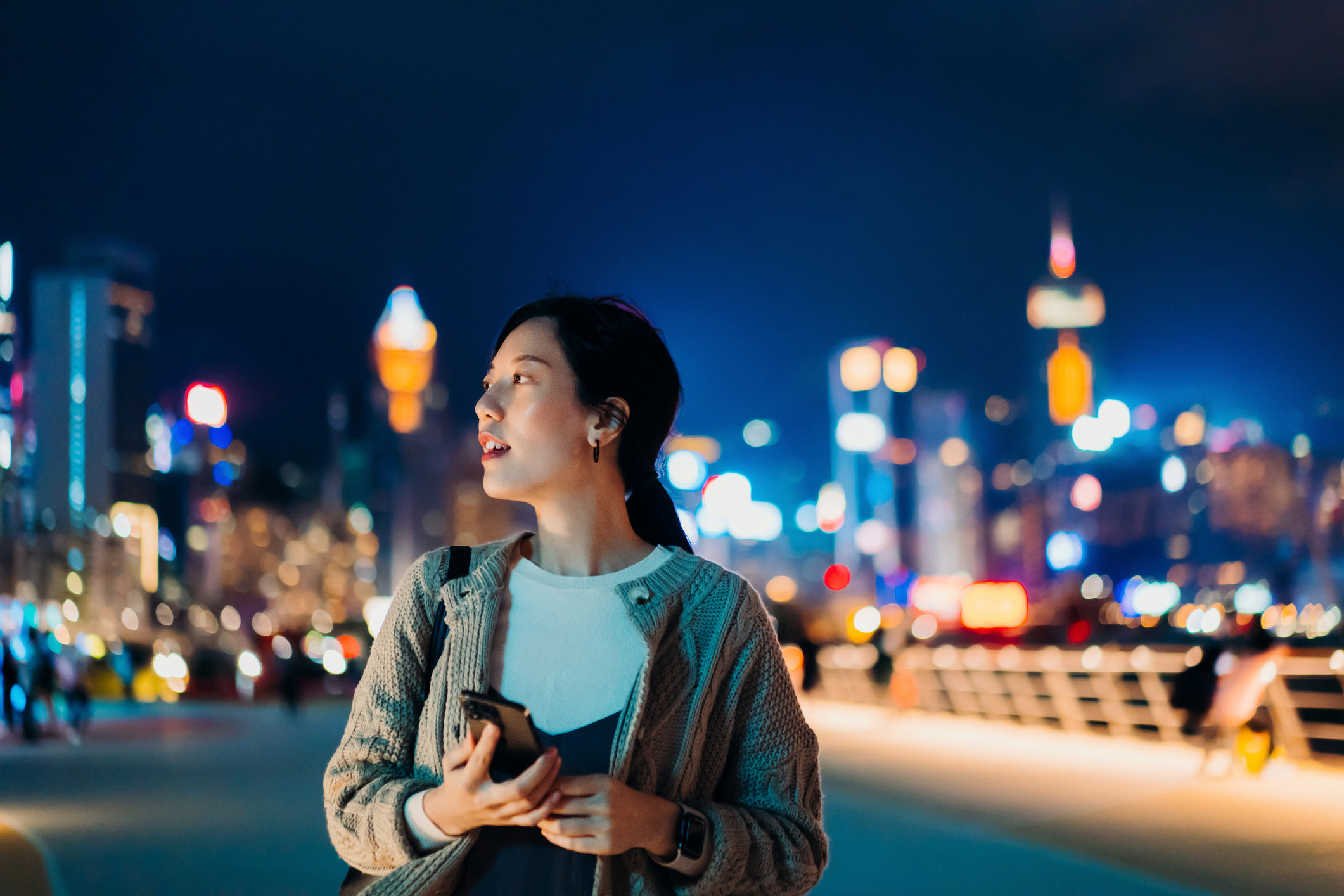 A woman walking on a city street at night