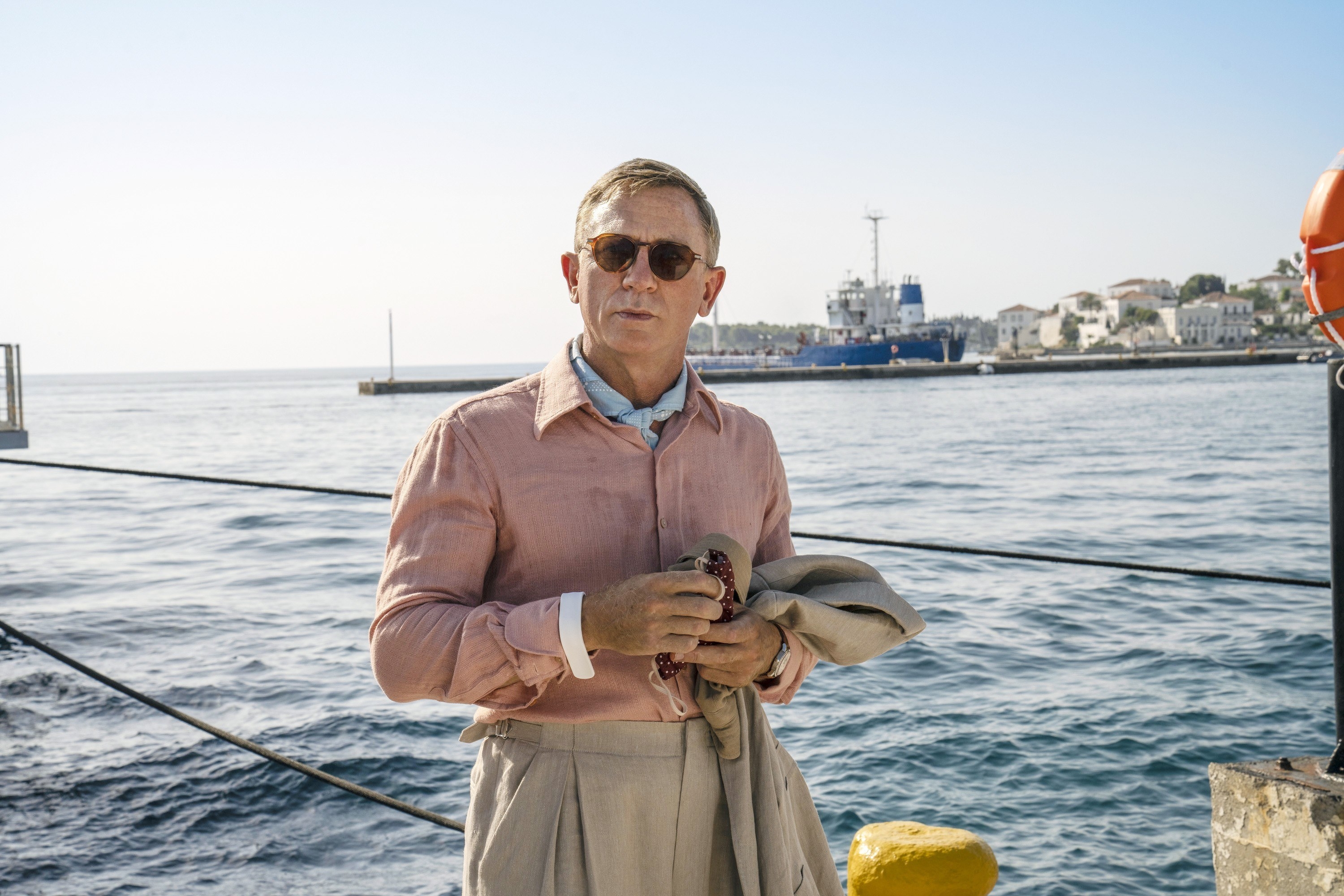 Daniel Craig stands on a boat dock