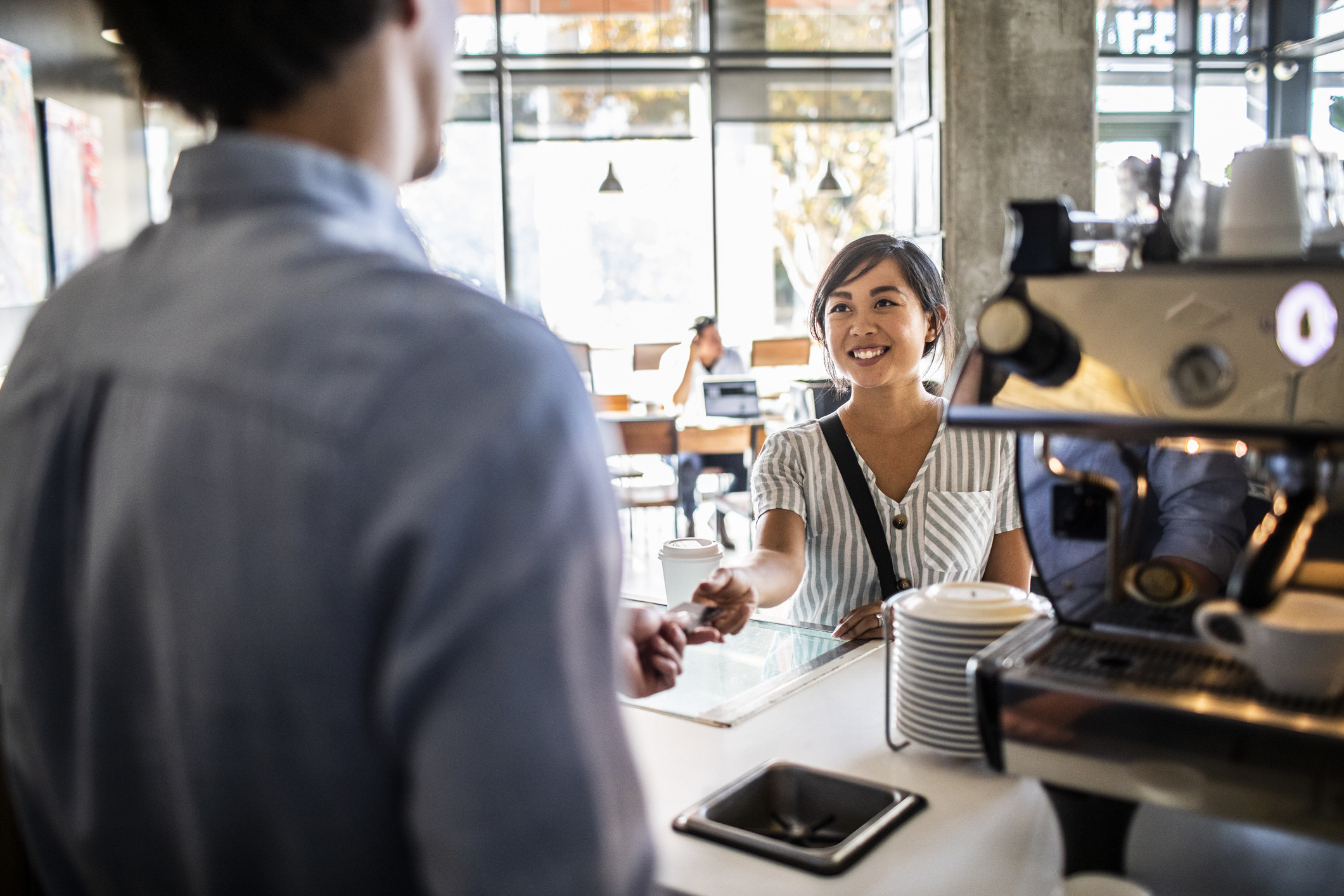 A young woman at the cash register in a restaurant