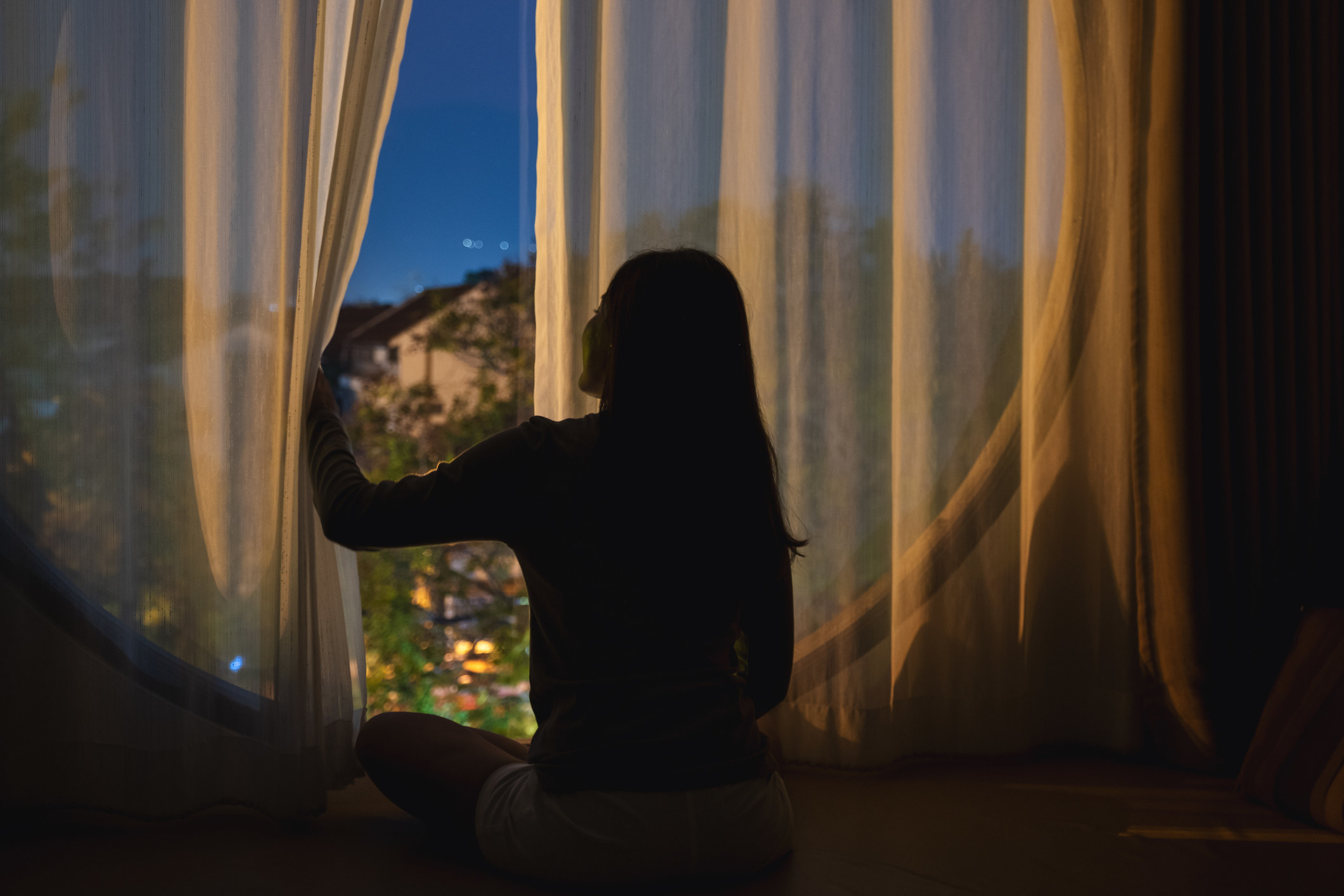 Woman sitting at a window at night