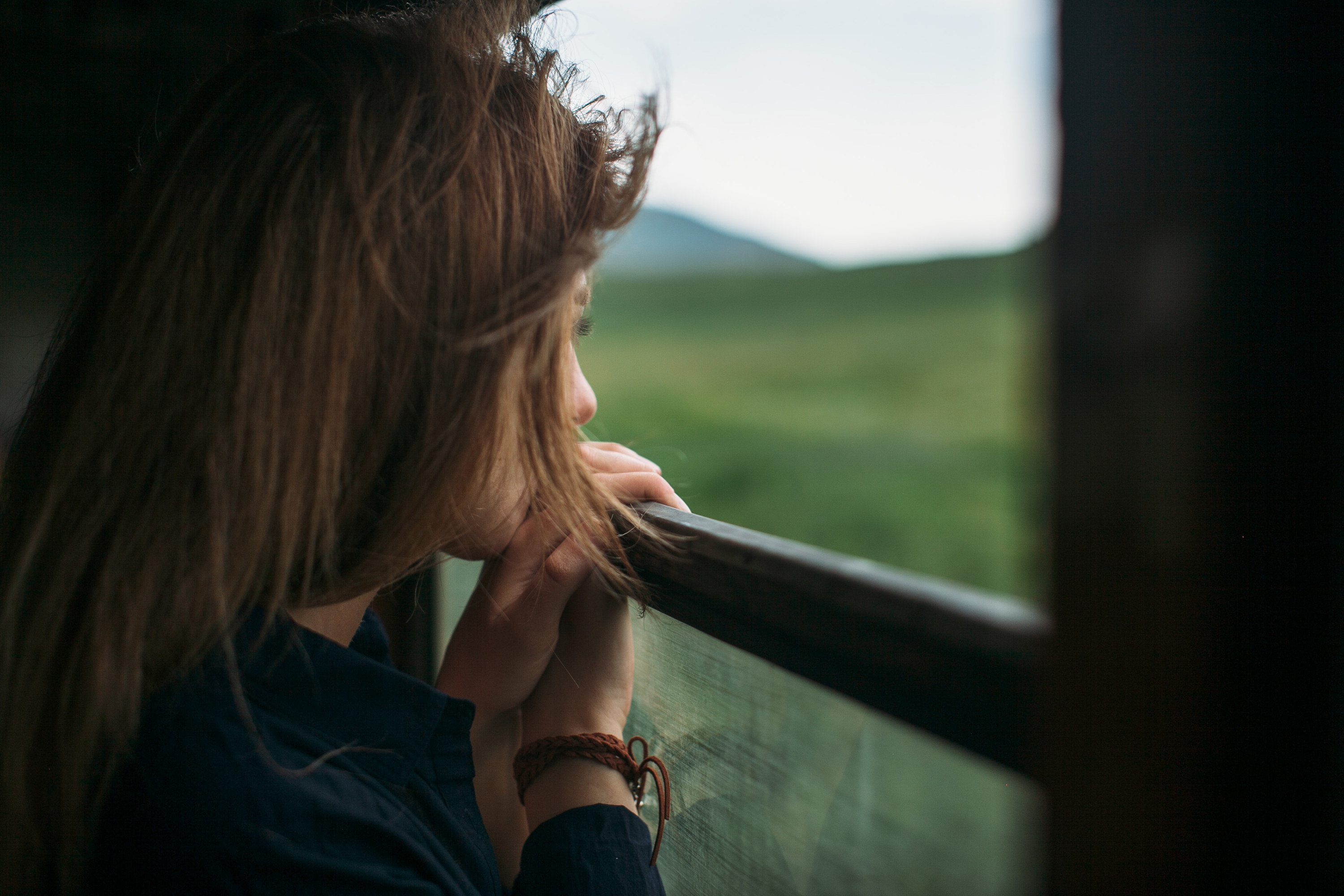 Woman looking out a window at grass