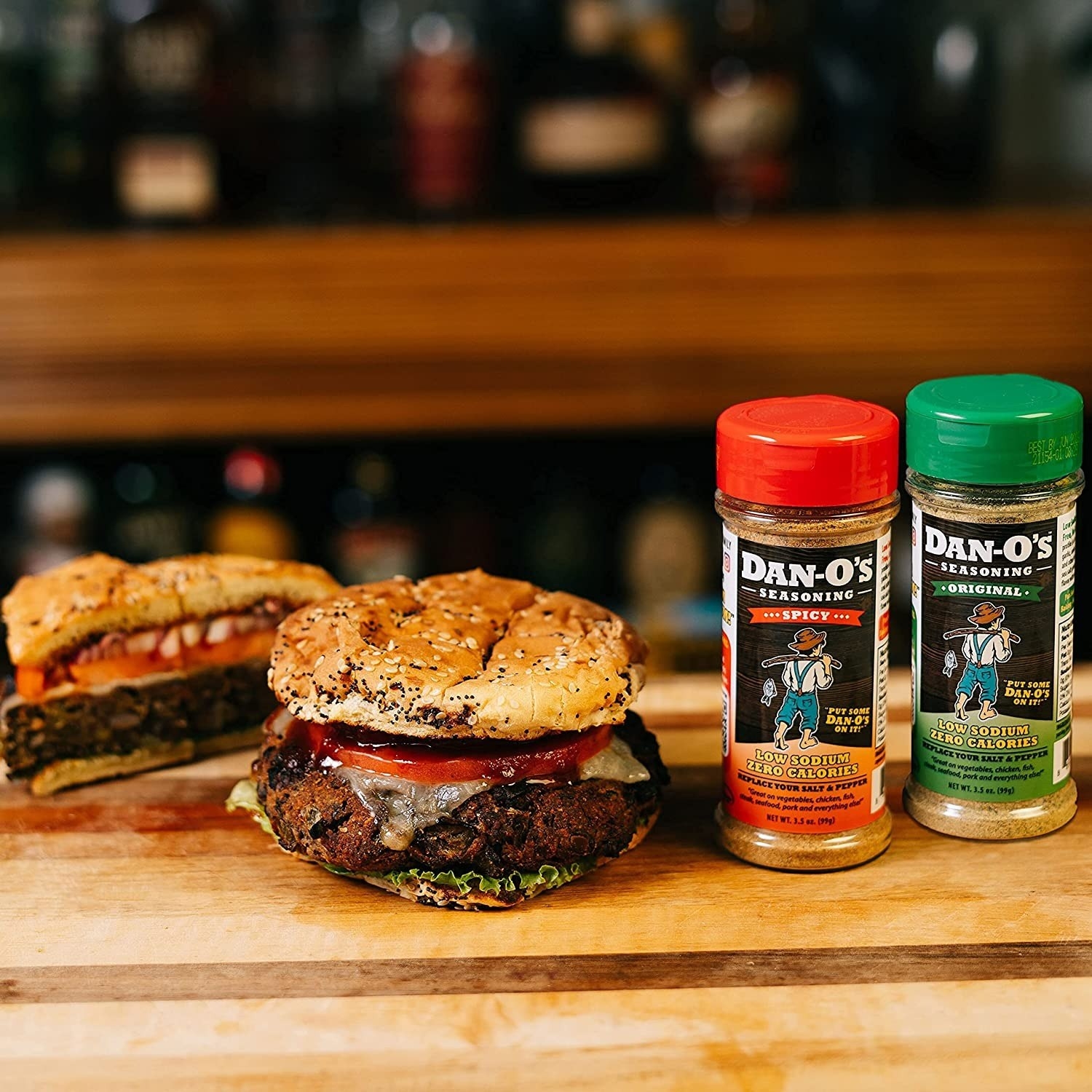 containers of Dan-O seasoning next to cooked burgers