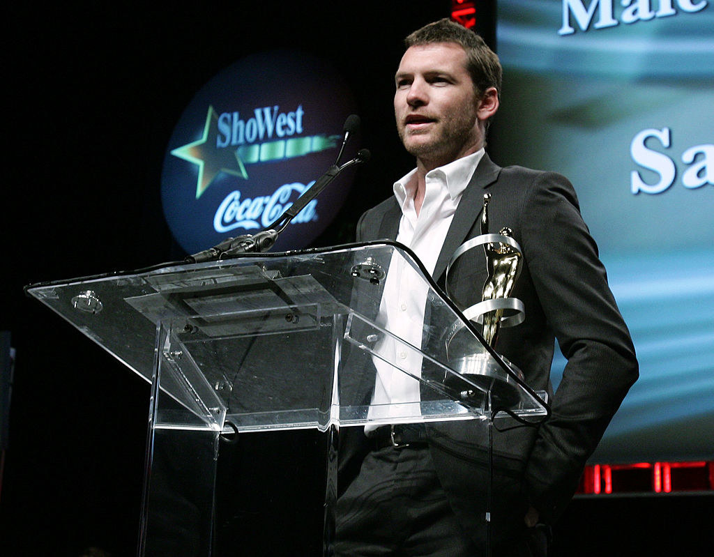 Sam at a podium with an award