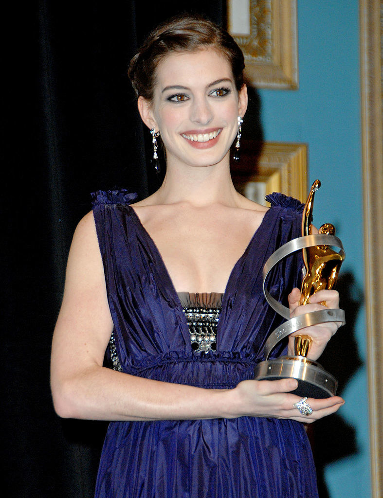 Anne smiling and holding an award