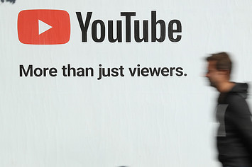 A man walks past a billboard advertisement for YouTube.