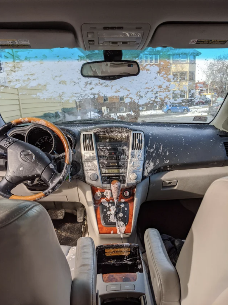 An exploded bottle of water on the car window and dashboard