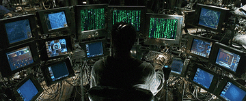 A man sits at an array of complex computers