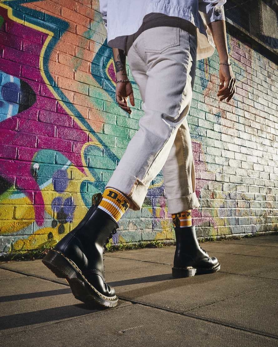 Woman walking down colorful street in Dr. Marten boots