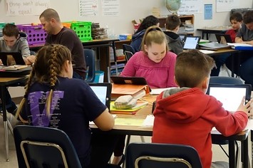 Students and teacher working in a classroom Wellsville, New York