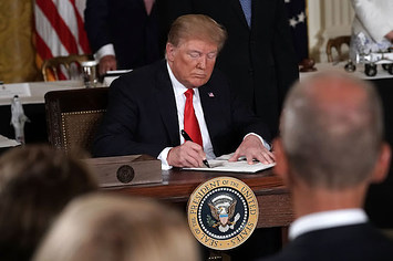 Donald Trump signs an executive order during a meeting of the National Space Council.