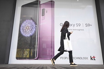 A woman walks past an advertisement for the Samsung Galaxy S9.