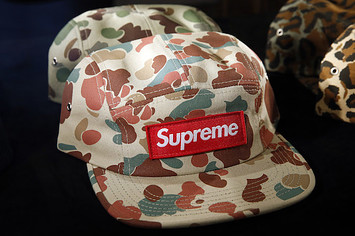 A cap entitled 'Duck Camo' by Supreme is displayed during exhibition.
