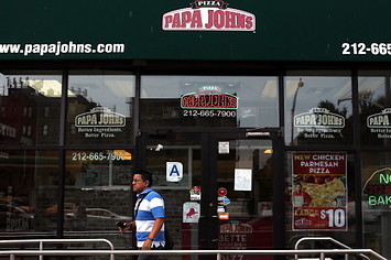A man walks by a Papa Johns pizza restaurant