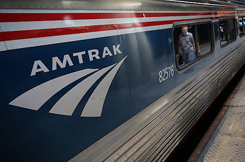 A passenger passes by an Amtrak train