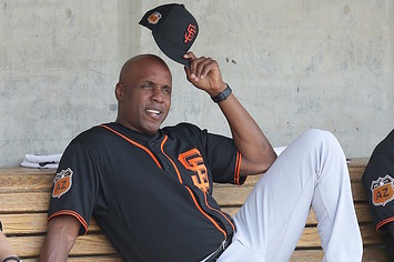 Barry Bonds sits in dugout during Giants' Spring Training game.