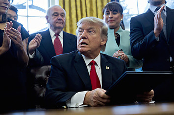 Donald Trump pauses after signing an executive order