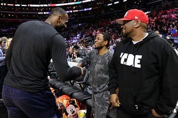 LeBron James shakes Kendrick Lamar's hand during a game in Los Angeles.