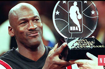 Michael Jordan holds up an All Star Game MVP Trophy