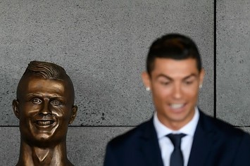 Cristiano Ronaldo stands in front of his statue.